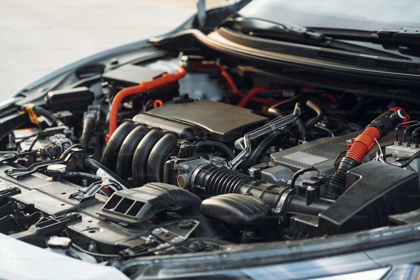 Car battery seated in an engine bay, terminals visible