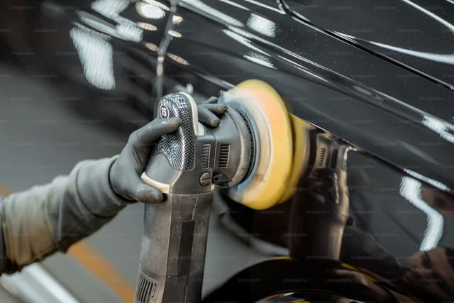 Machine polisher being used on car paintwork during detailing