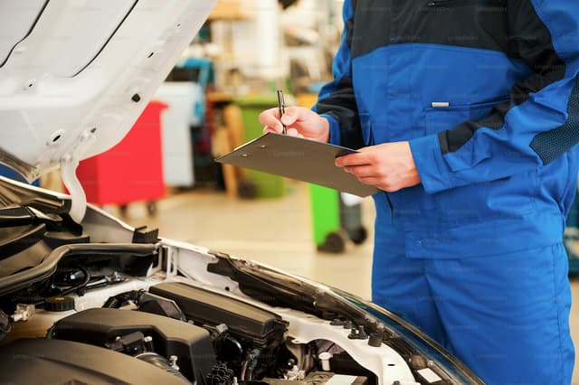 Technician working through a vehicle inspection checklist