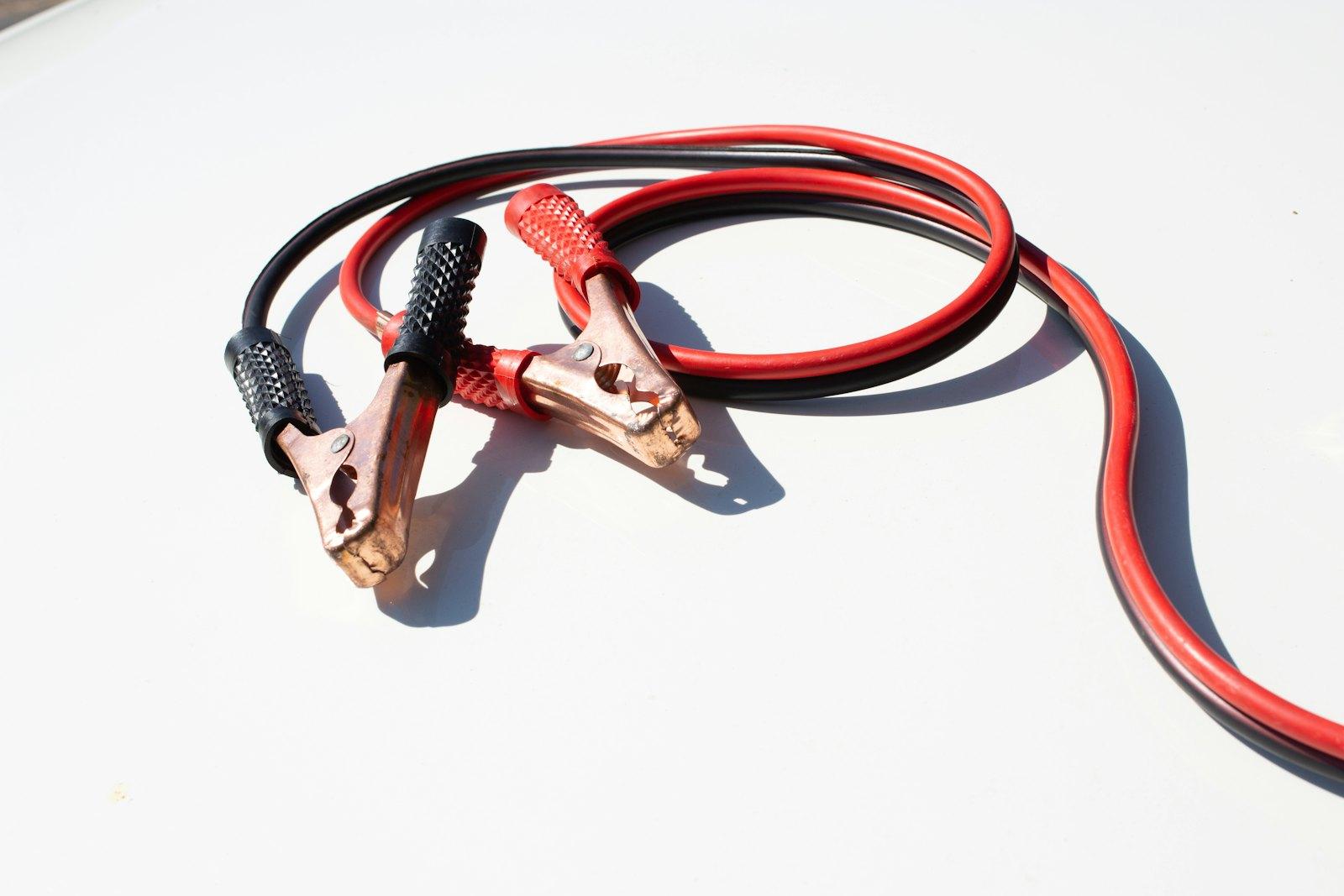 Jumper cables clamped to a car battery for a jump start