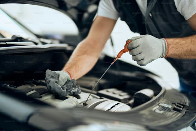 Fresh engine oil being poured during an oil change